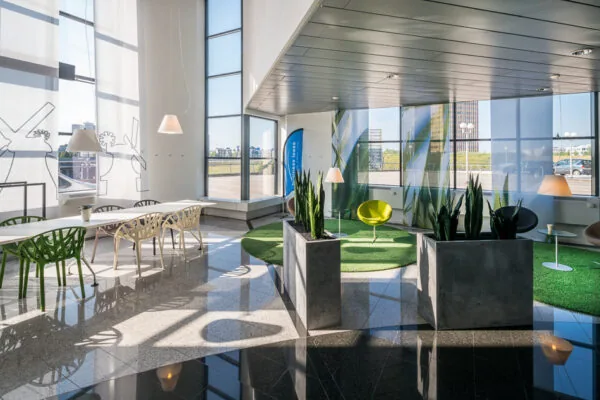 Moderne en lichte wachtruimte in het Rivium Quadrant met designstoelen, plantenbakken en grote ramen met uitzicht.